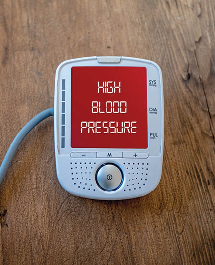 Medical device show high blood pressure on monitor. Digital measuring of health. Text on red varning display.