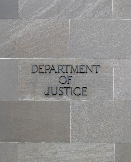 Department of justice sign on stone wall in Washington DC, USA